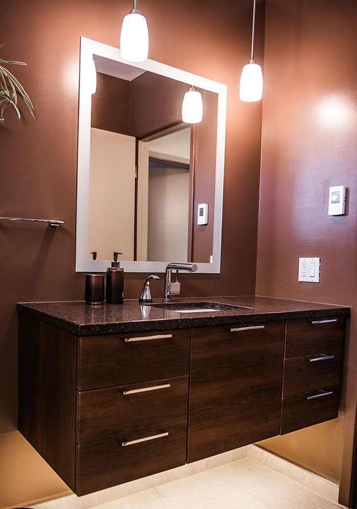 Bathroom painted brown with dark wood floating cabinet and sink