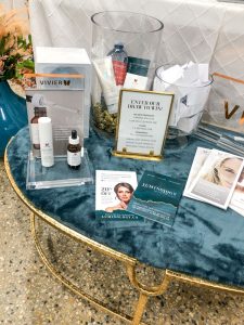 Facial & beauty products on a blue velvet table with gold legs